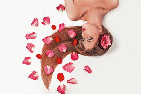 瑰玫摄影照片_美丽的女孩放松区，躺在玫瑰花瓣中