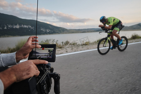 摄影师拍摄铁人三项自行车运动员的动作镜头