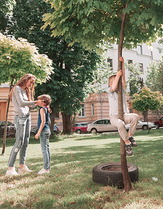 母亲和孩子们摄影照片_母亲和孩子们在城市院子里玩耍。