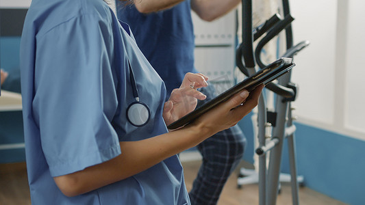 穿制服的健康专家使用数字平板电脑帮助老年患者