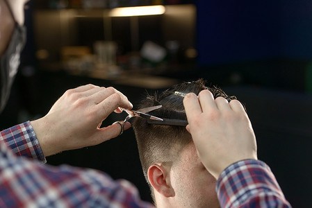 理发师男手在剪男发时的特写