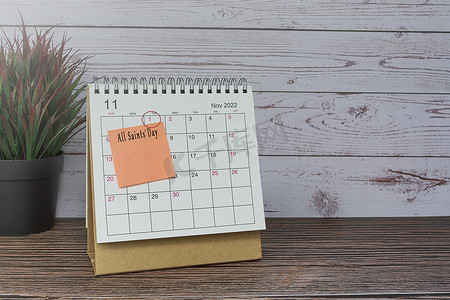 2022 年 11 月的日历在木桌上，日期圈和便利贴上的文字。