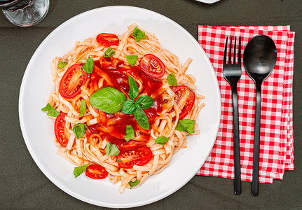 一盘意大利面配美味的番茄酱和罗勒叶的俯视图。