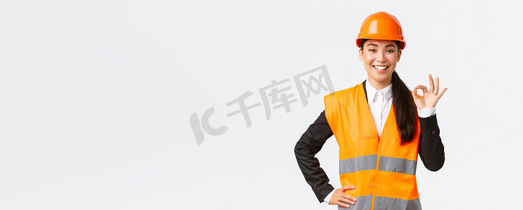 自信的亚洲专业女建筑师安全头盔确保质量和工作及时，表现出良好的姿态和微笑坚定，坚定自信，确保和保证某事
