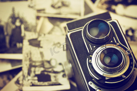 家庭照片摄影照片_旧相机躺在老式家庭照片上