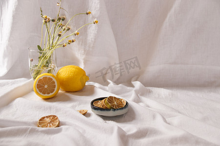 春天背景色摄影照片_新鲜和干柠檬的极简静物画