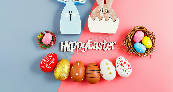 复活节快乐假期背景概念。在办公桌现代漂亮的灰粉色纸上平躺着五颜六色的兔子蛋。