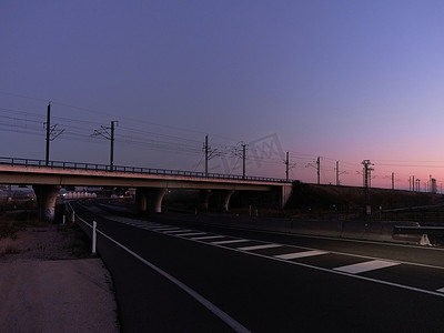 日落时穿越高速公路的铁路桥