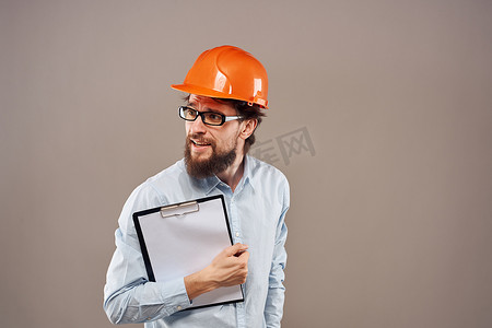 一个身着橙色油漆、手里拿着文件的男人正在建立一家工业企业