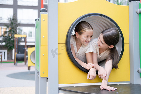 户外的孩子们在现代化的游乐场上玩着色彩缤纷的新设备。