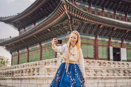 韩服女摄影照片_在韩国宫殿穿着韩服的年轻白人女游客。
