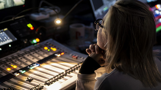 俄罗斯 2020 年 10 月。女音响工程师在调音台的广播中工作。