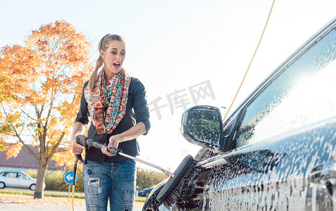 在自助洗车中清洁车辆的妇女