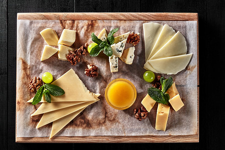 木板上的苏尔古尼切片、马苏里拉奶酪、多尔蓝奶酪和半硬奶酪