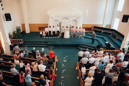 美国萨克拉门托 - 2018 年 5 月 12 日：新娘和新郎在教堂举行婚礼，并在宾客面前接受祝福。