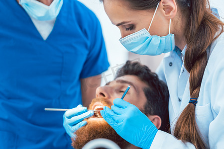 可靠的牙医在清洁牙齿时使用无菌器械