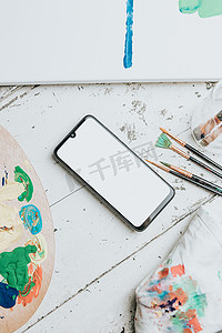 模拟手机摄影照片_用调色板和画笔模拟手机在白色桌子上的图像。