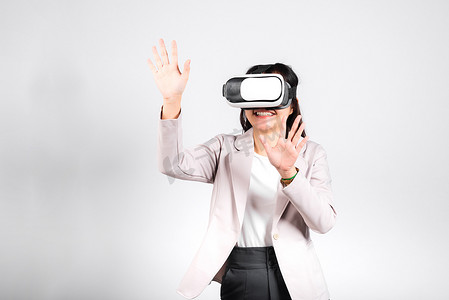 微笑的女性自信兴奋地佩戴 VR 耳机设备在虚拟现实体验中触摸空气