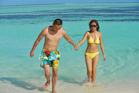 约会夏天摄影照片_亚洲夫妇在海滩上享受夏天