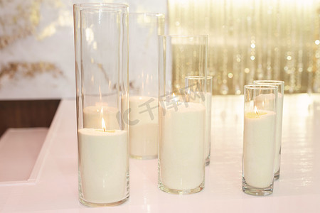 金色婚礼装饰摄影照片_白色和金色风格的婚礼装饰，配有蜡烛和鲜花