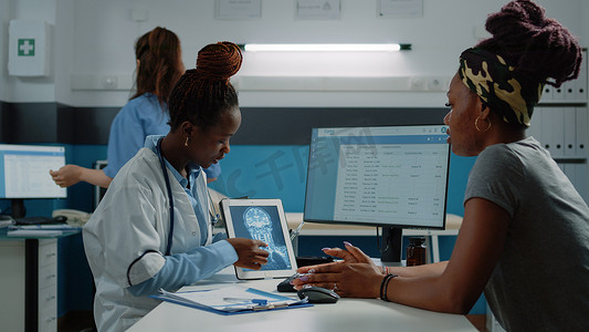 医生在平板电脑上进行 X 射线扫描，以便与患者会诊