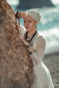 中年妇女金发碧眼，波西米亚风格，脖子和手臂上戴着白色长裙，戴着沙滩装饰。