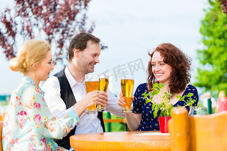 喝啤酒摄影照片_朋友们在花园餐厅喝啤酒
