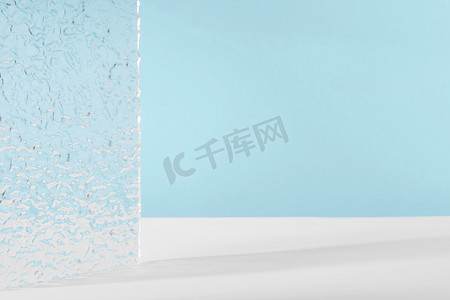透明亚克力透明摄影照片_亚克力罗纹板，蓝色背景下化妆品包装的背景。