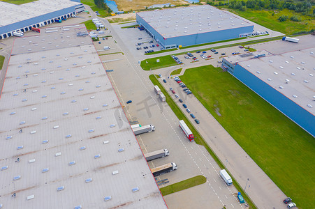 货车仓库摄影照片_工业仓库装卸码头的空中拍摄，许多卡车与半拖车装载商品。