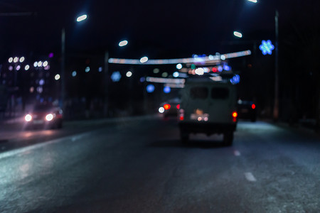 夜间街道汽车交通的离焦图片-从道路上看。