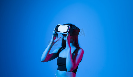 微笑快乐的女人获得使用虚拟现实 vr 耳机眼镜的经验，在灰色背景上比划手。