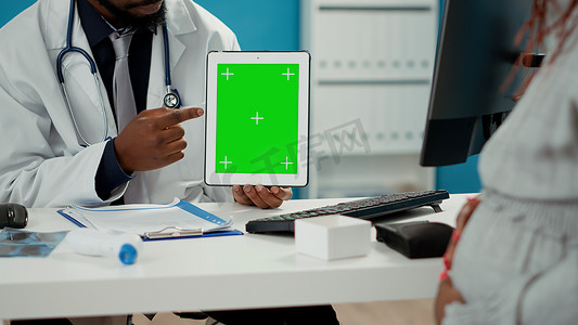 在平板电脑显示器上使用绿屏模板的男性产科医生
