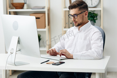 戴眼镜的商人坐在办公桌前工作的技术