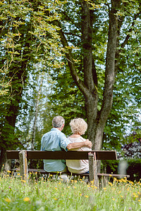 浪漫的老夫妇一起安静地坐在长凳上