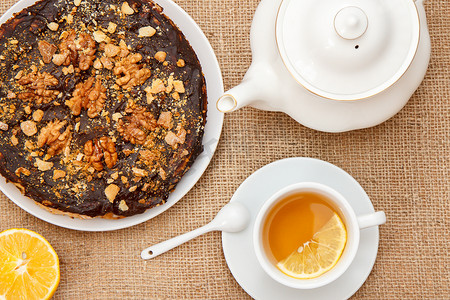 一杯茶，配柠檬片、瓷茶壶和自制巧克力蛋糕