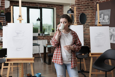 美术老师站在创意工作场所喝咖啡的画像