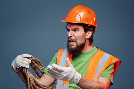 身穿工作制服橙色漆绳的男子手握辛勤工作的裁剪视图