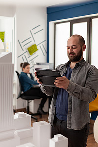 专业建筑师在视频通话会议中手持平板电脑微笑