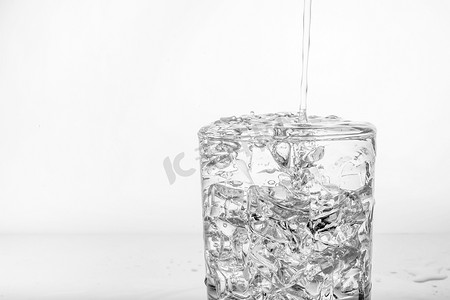 杯子加冰块摄影照片_玻璃杯加冰和泼水