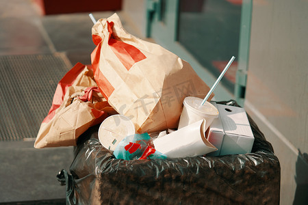 垃圾里有一堆纸包、咖啡杯和其他饮料。