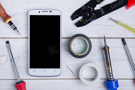 智能手机和设备维修白色木制背景。