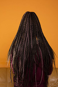 女性的头发扎成许多小辫子，创造出一种有趣的发型。