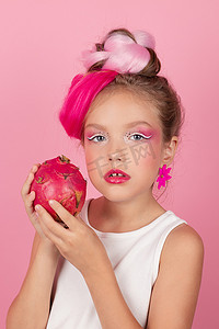 漂亮女孩的特写肖像，有粉红色的发型，粉红色的背景上有火龙果。