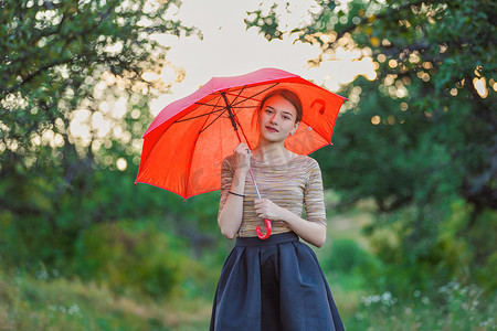 下雨打伞摄影照片_大自然中打伞的女孩