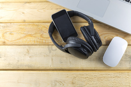 耳机、键盘、鼠标和音乐便携式在木桌上