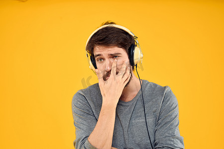 戴耳机音乐生活方式生活方式科技黄色背景的男人
