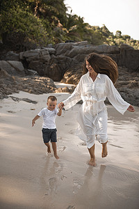 欧洲家庭摄影照片_快乐的微笑欧洲家庭在白色沙滩上休息和奔跑