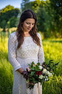 美丽的新娘在户外举行婚礼，新婚快乐的女人带着结婚花束。