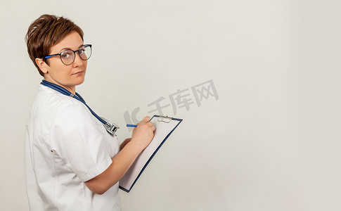 写下摄影照片_女医生用笔在平板电脑上写下一份文件，写下病史。