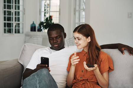 一个快乐的女人和一个非洲人长相的男人正在检查手机。